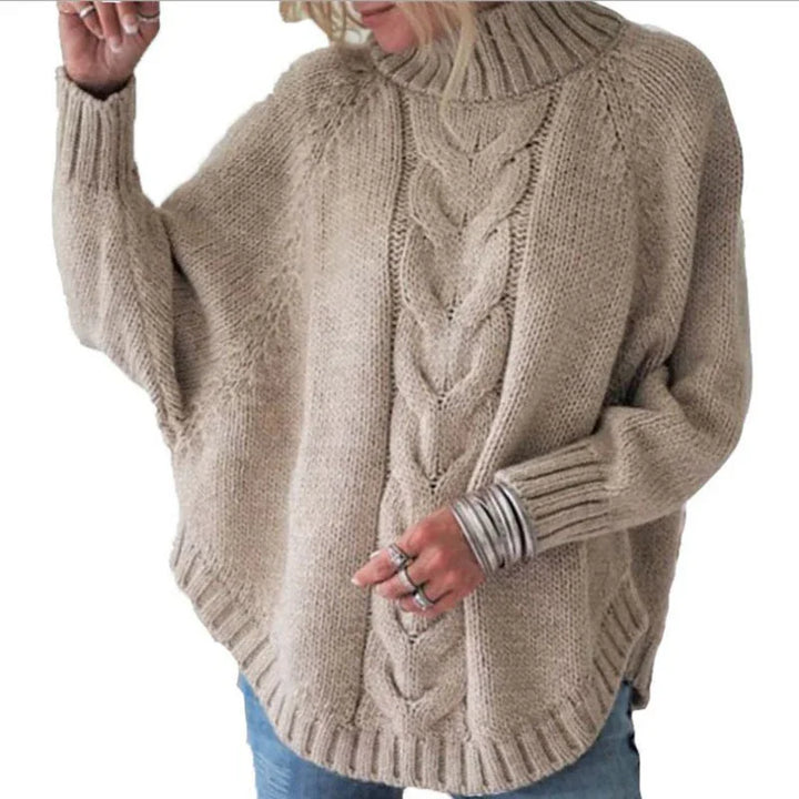 Beige chunky knit turtleneck sweater with cable pattern, worn with silver rings and bracelets