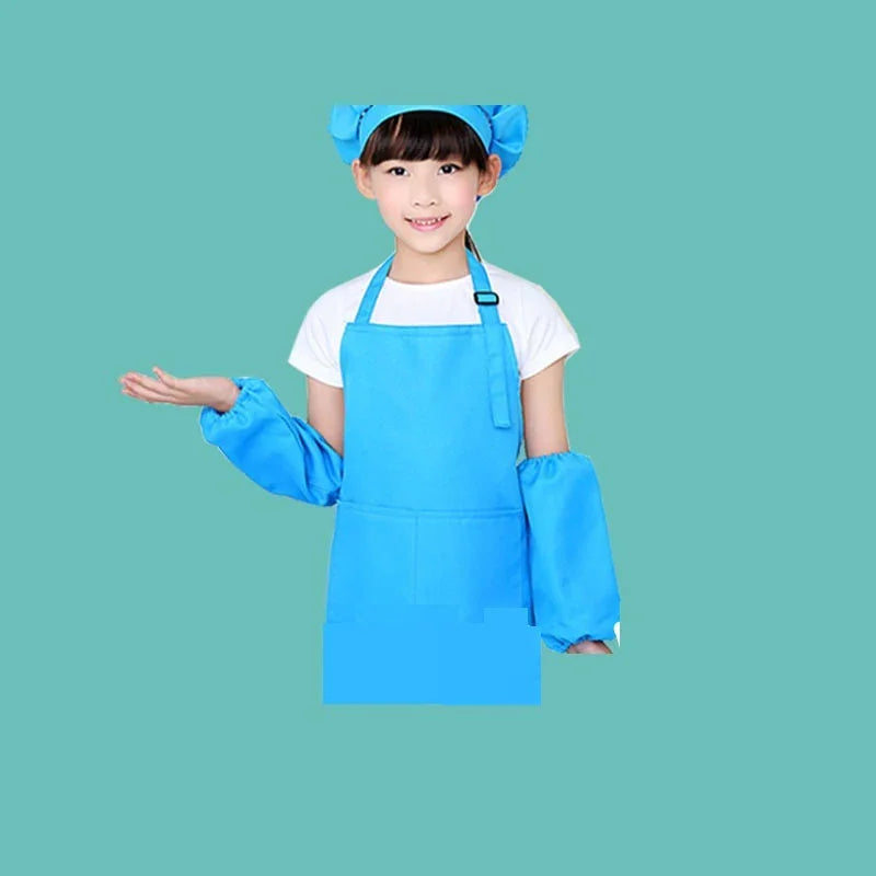 Young girl wearing blue chef hat, apron, and sleeve covers on teal background