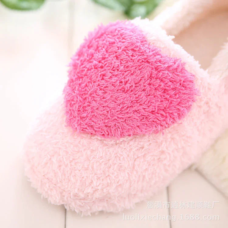Close-up of soft pink fuzzy slipper with a large bright pink heart on top