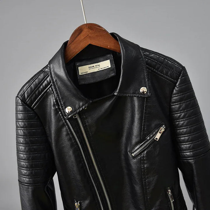 Black faux leather biker jacket with quilted shoulders and silver zippers on wooden hanger