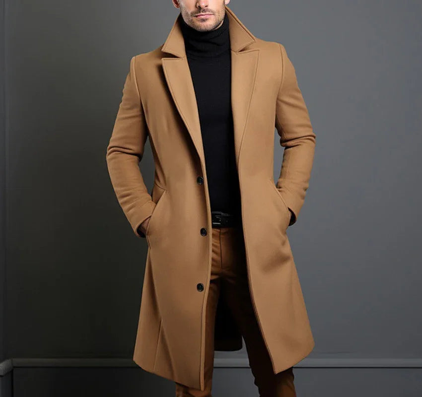 Man wearing a stylish camel overcoat and black turtleneck sweater against gray background