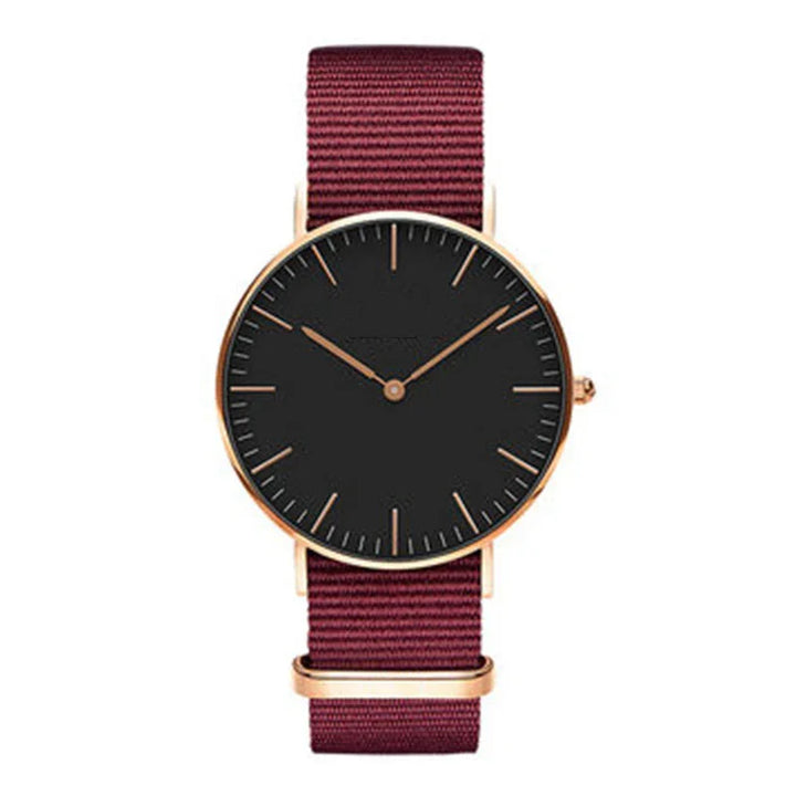 Minimalist wristwatch with black dial, rose gold case, and burgundy nylon strap