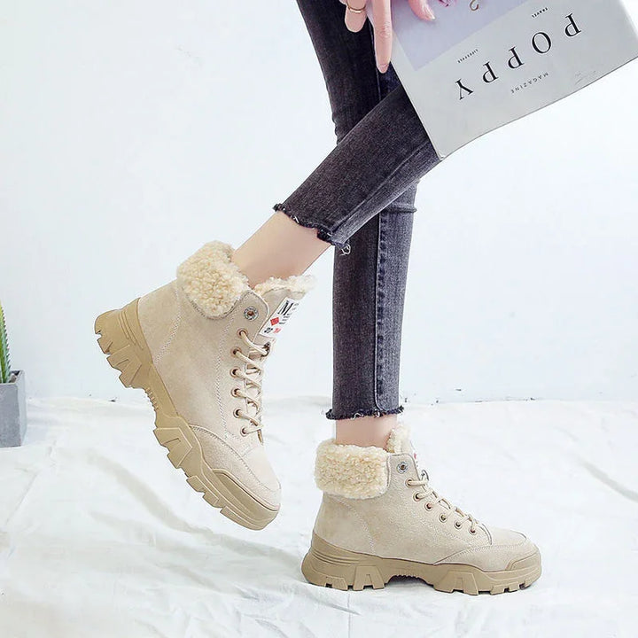 Beige winter boots with faux fur lining worn with black cropped jeans, holding a magazine