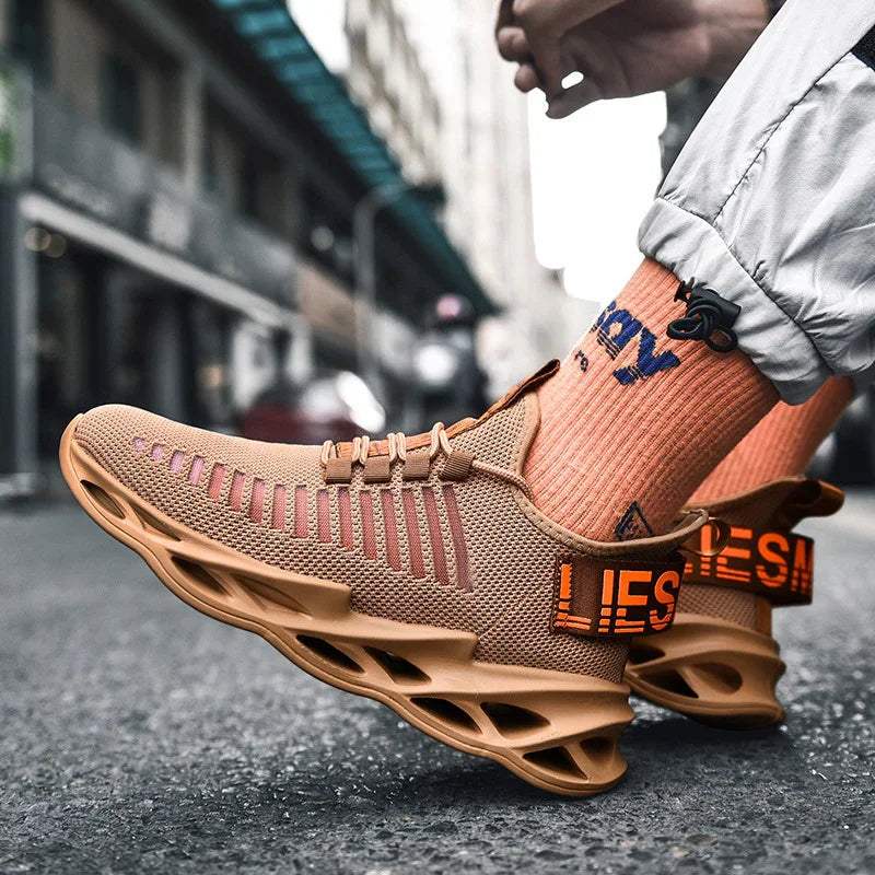 Modern tan mesh sneakers with unique ventilated soles and orange 'LIES' detail worn with orange socks on city street