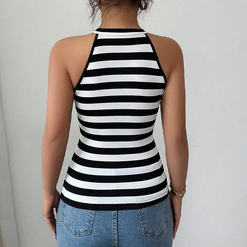 Woman wearing black and white striped sleeveless halter top paired with blue denim jeans