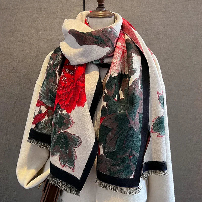 Beige scarf with large red flowers and green leaves displayed on a white mannequin against gray background