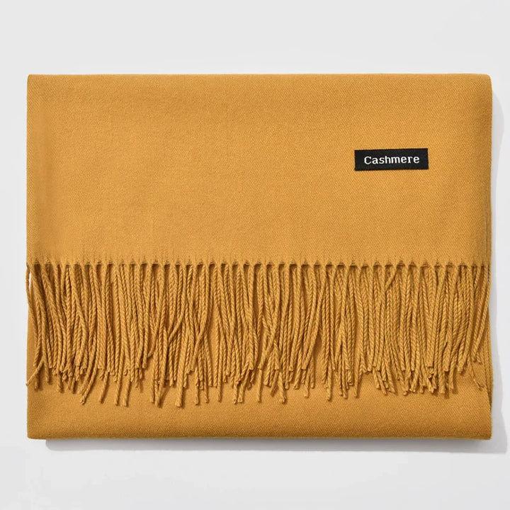 Folded mustard yellow cashmere scarf with fringed edges and black label