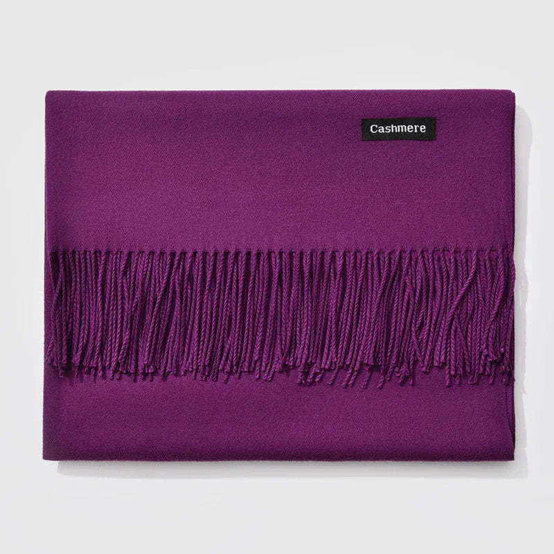 Folded purple cashmere scarf with fringed edges and black label on white background