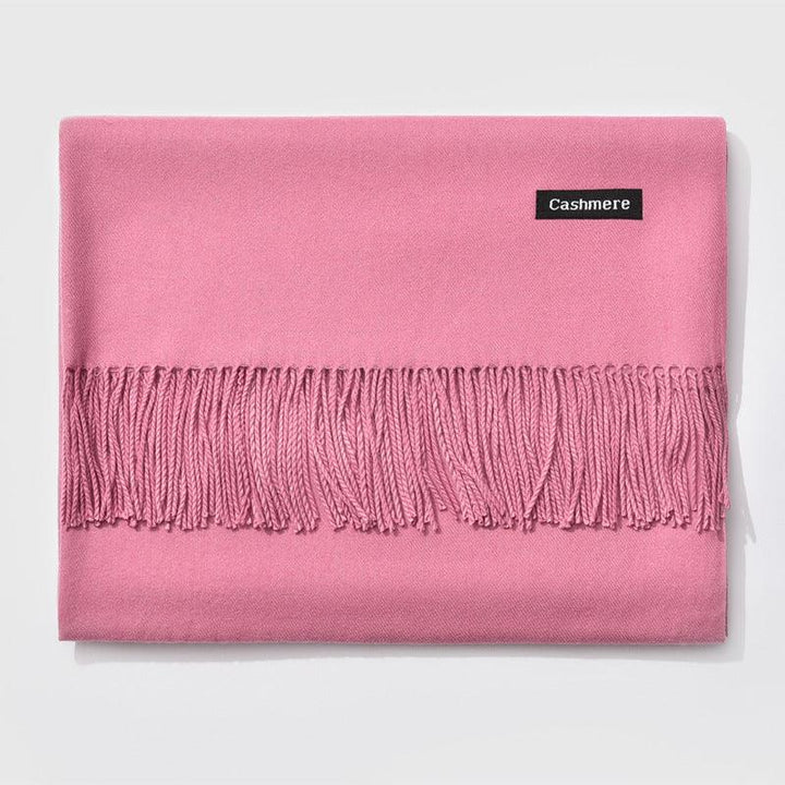 Soft pink cashmere scarf with twisted fringe detail and label on white background