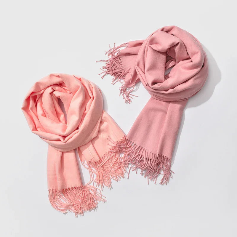 Two soft scarves in pale pink and dusty rose with fringed ends on white background