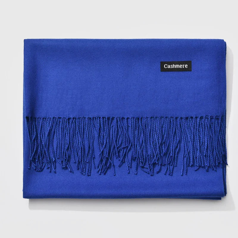 Folded bright blue cashmere scarf with fringed edges on white background