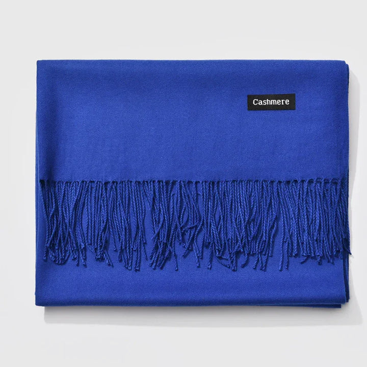 Folded bright blue cashmere scarf with fringed edges on white background