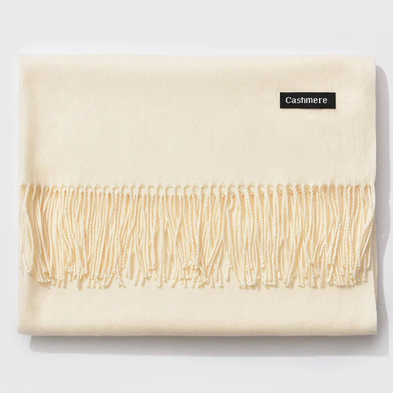 Soft ivory cashmere scarf with fringed edges and a black label on a white background