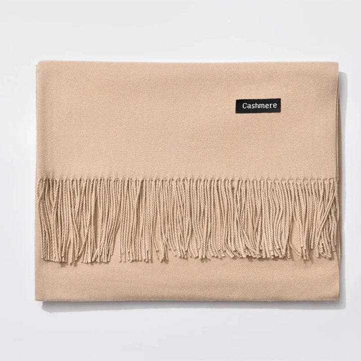 Beige cashmere scarf with fringed edge and black label on white background