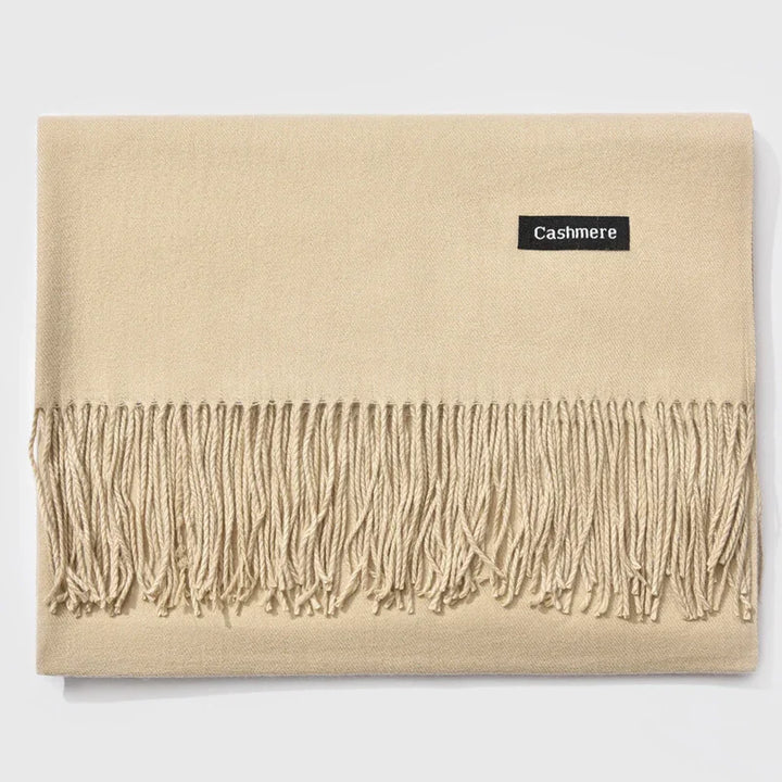 Soft beige cashmere scarf with fringed edges and a black label reading 'Cashmere'