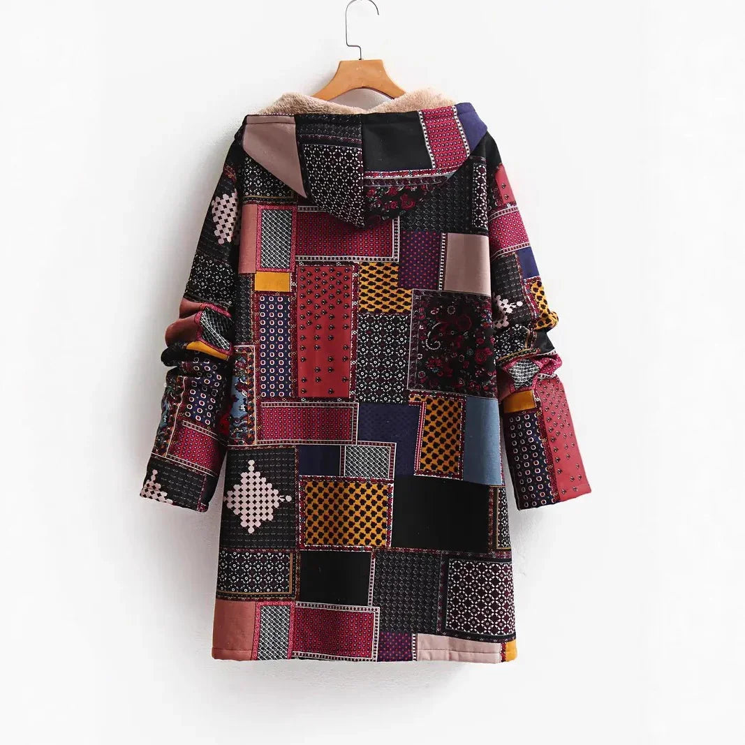 Patchwork hooded winter coat with colorful patterned fabric and soft lining, hanging on wood hanger