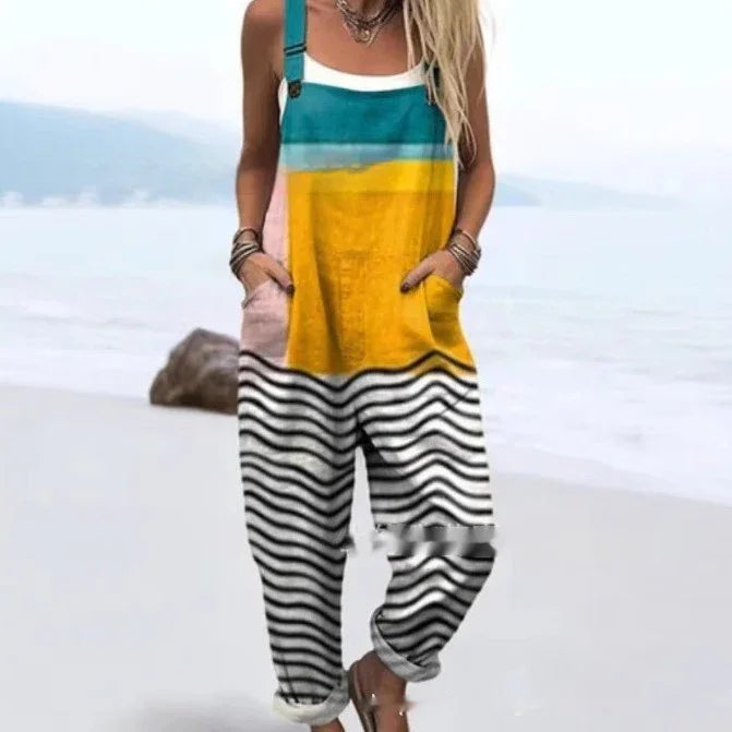 Woman wearing colorful striped overalls with blue, yellow, pink, and black-white waves, standing on beach