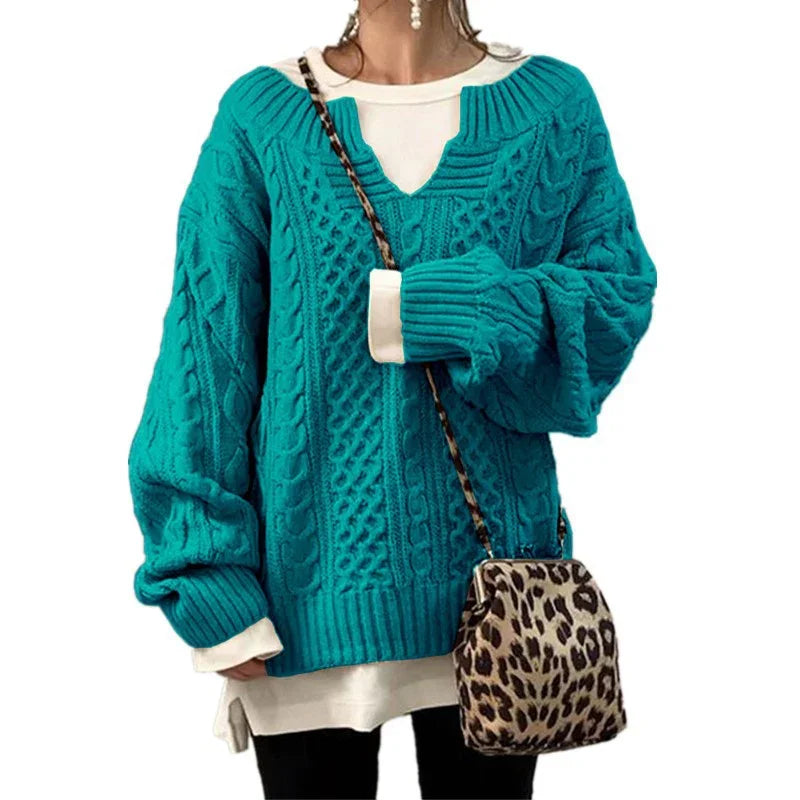 Woman wearing a teal cable knit sweater with v-neck over white shirt, paired with leopard print crossbody bag