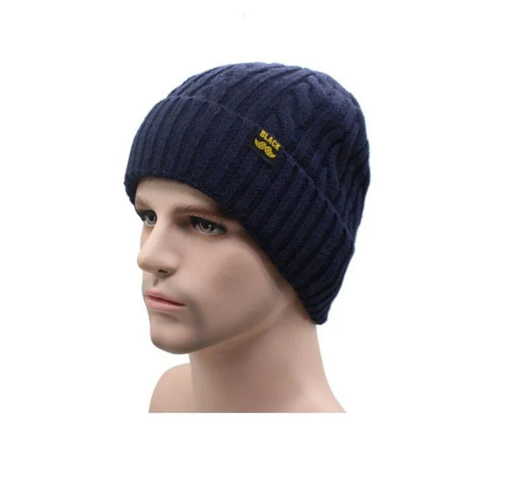 Mannequin wearing navy blue cable knit beanie with 'BLACK' yellow tag on white background