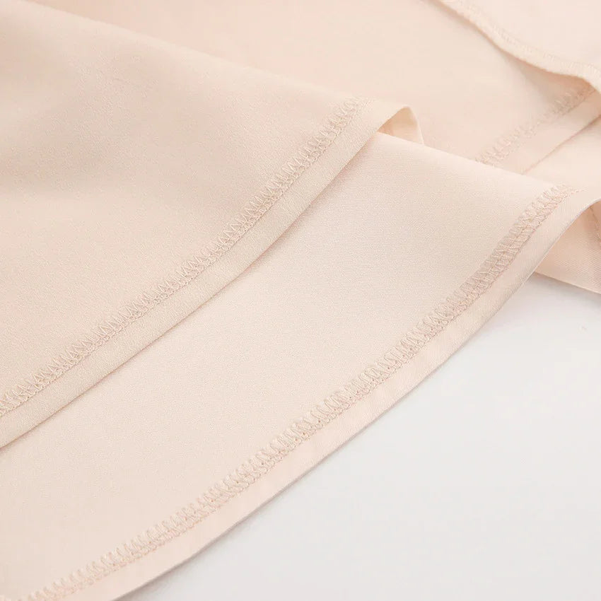 Close-up of beige lightweight fabric with visible stitching and smooth texture
