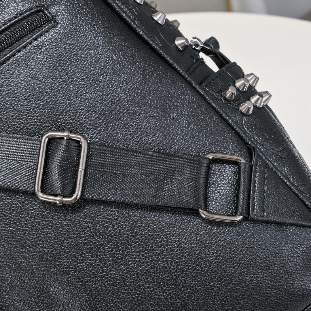 Black leather bag with adjustable black strap and metal buckles, featuring silver spikes on top