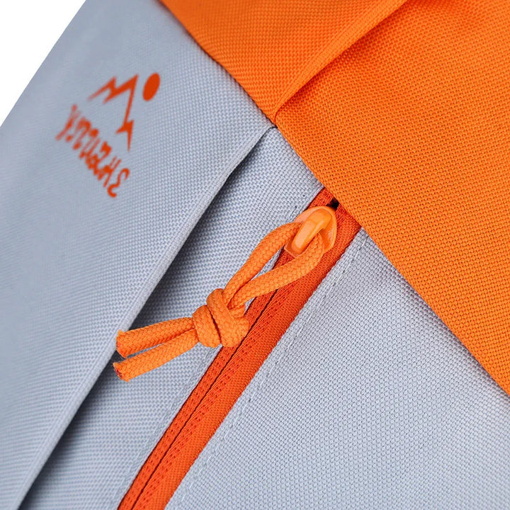 Closeup of orange and gray backpack zipper with outdoor logo and durable fabric