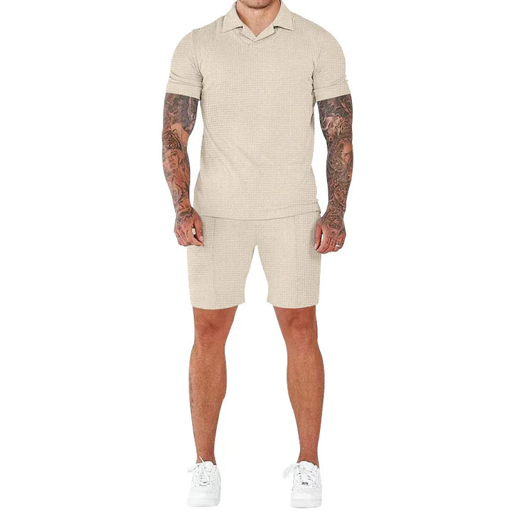 Man wearing beige waffle knit short sleeve polo and matching shorts with white sneakers