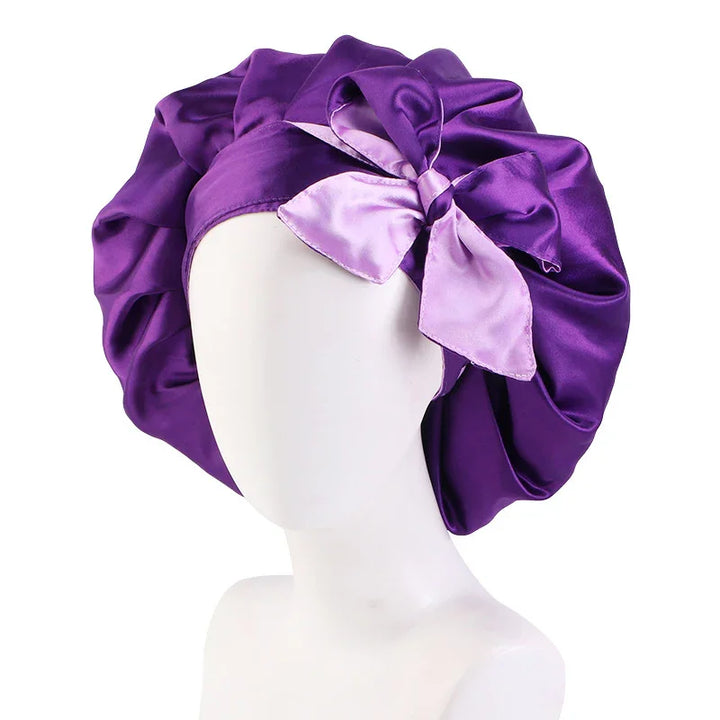Purple satin bonnet with a large decorative bow on a white mannequin head