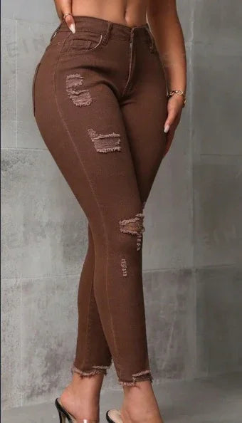 Close-up of a woman wearing brown distressed skinny jeans with frayed hems and high heels