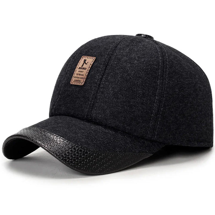 Black wool baseball cap with textured leather brim and small brown logo patch