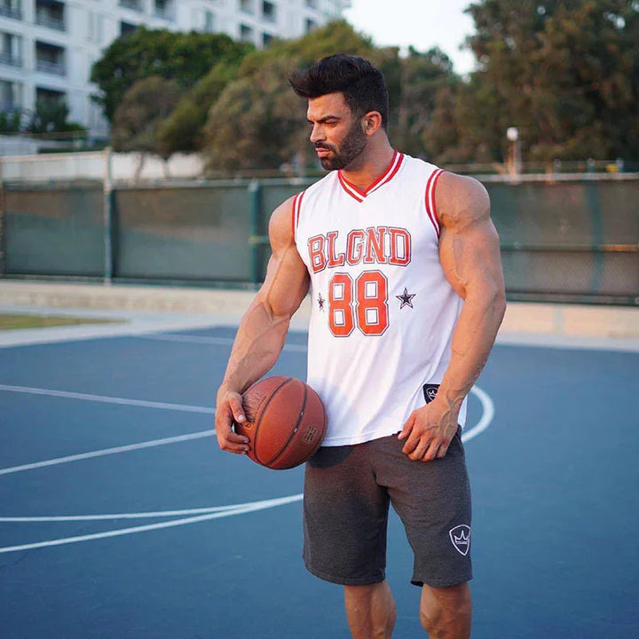 muscular man in white BLGND 88 basketball jersey holding basketball on outdoor court