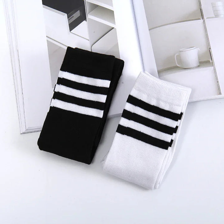 Folded black and white striped socks on magazine pages with minimalist home decor images