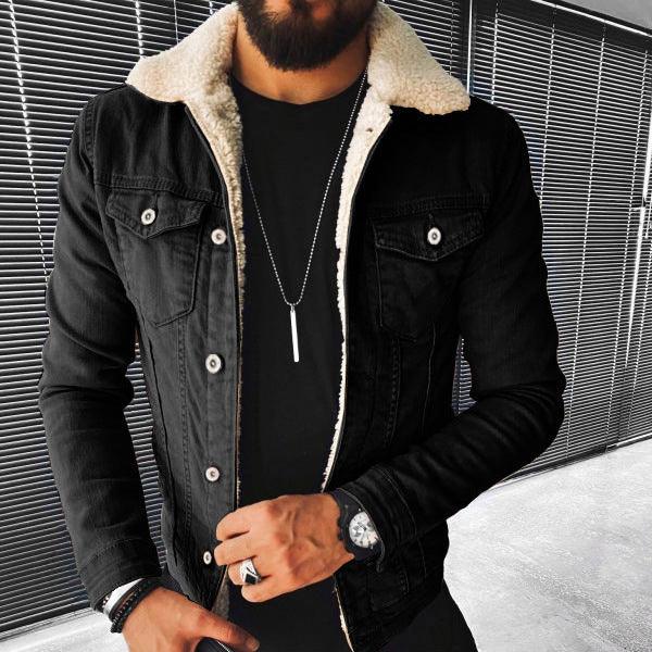 Man wearing black sherpa-lined denim jacket over black shirt with necklace and watch