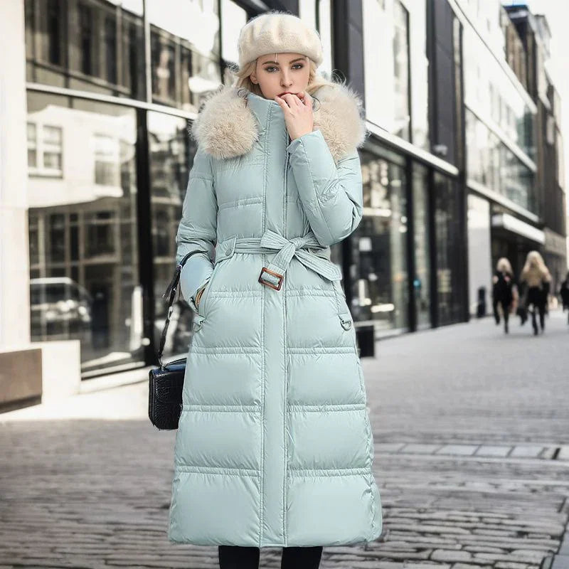 Woman wearing light blue belted puffer coat with fur collar and cream beret on urban street