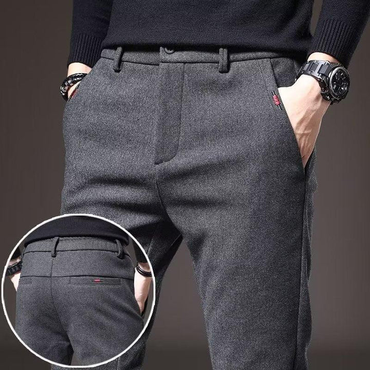 Men's grey slim-fit trousers with side and back pockets, worn with black sweater and accessories