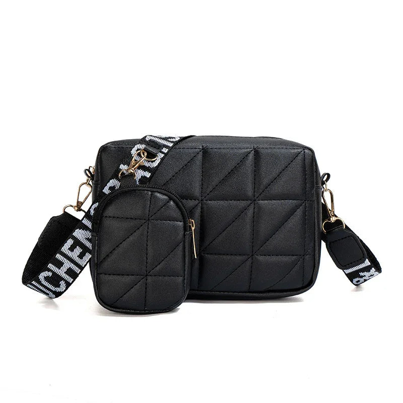 Black quilted crossbody bag with detachable smaller pouch and wide black strap with white lettering