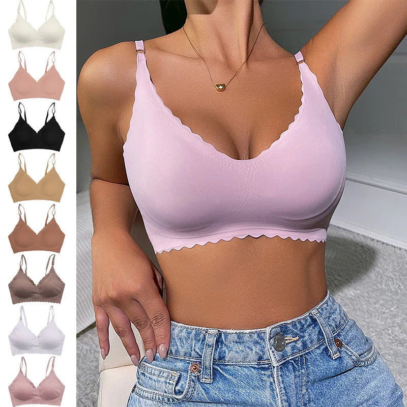 Woman wearing light pink seamless bralette with scalloped edges and adjustable straps, paired with high-waisted blue jeans