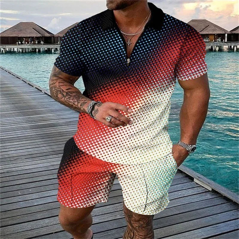 Man wearing gradient dotted black red white casual shirt and shorts standing on wooden pier by turquoise tropical water