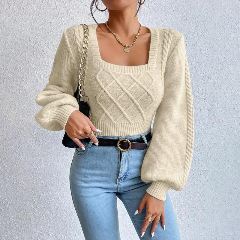 Woman wearing cream knit sweater with diamond pattern and puff sleeves paired with light blue jeans and black belt