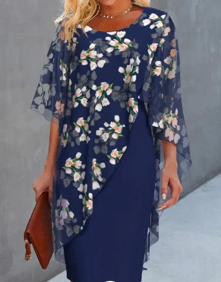woman wearing elegant navy blue floral overlay dress with sheer sleeves holding brown clutch