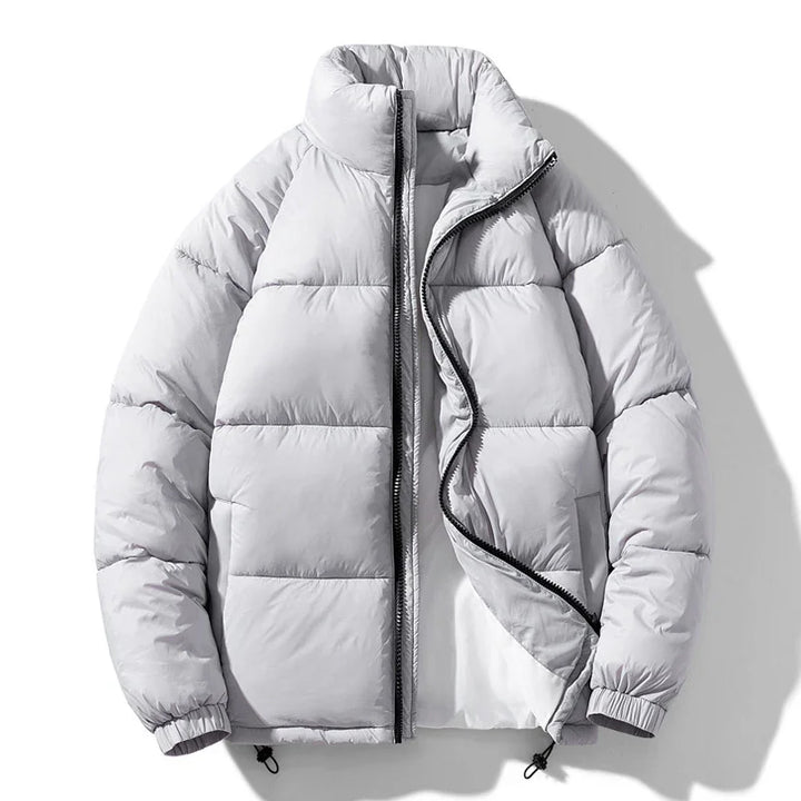 Light gray puffer jacket with high collar and black zipper on white background
