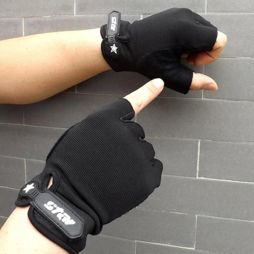 Black fingerless cycling gloves on hands against gray tiled wall