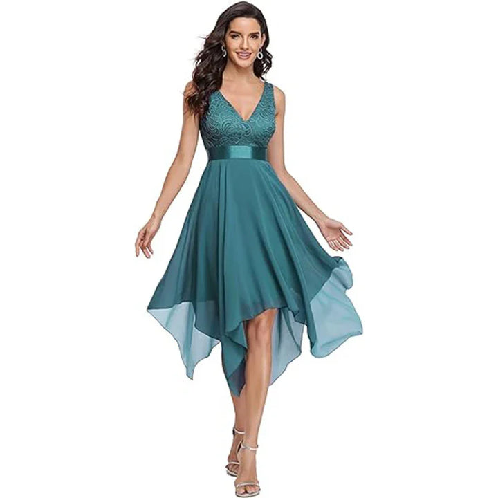 Woman wearing teal sleeveless high-low dress with lace bodice and satin waistband, posing in sandals