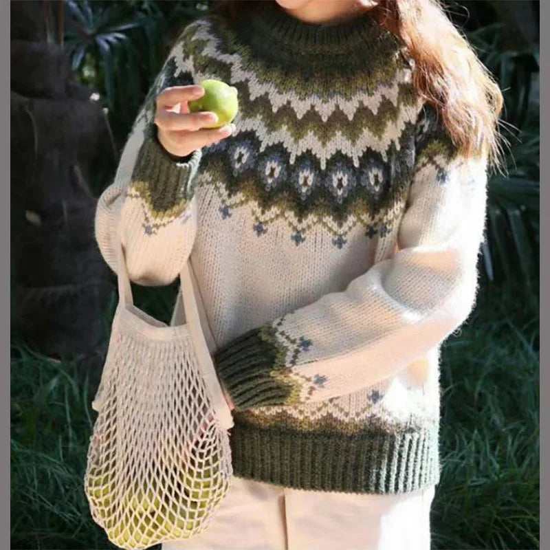 Woman wearing patterned wool sweater holding green apple and mesh tote bag outdoors