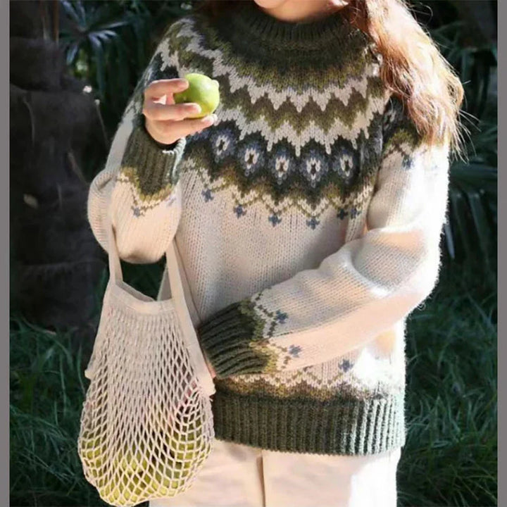Woman wearing patterned wool sweater holding green apple and mesh tote bag outdoors