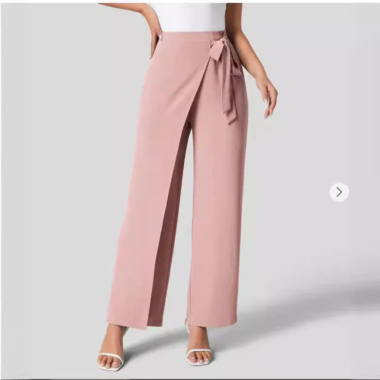 Woman wearing blush pink wide-leg wrap pants with side tie belt and white sandals