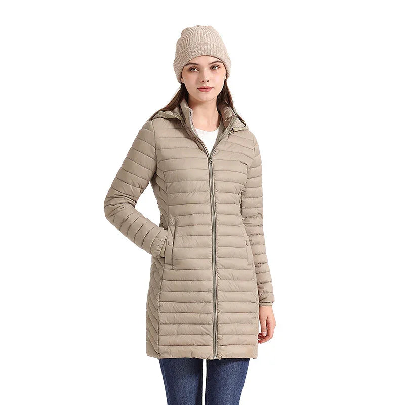 Woman wearing beige long quilted puffer jacket with front zipper and beige knit beanie