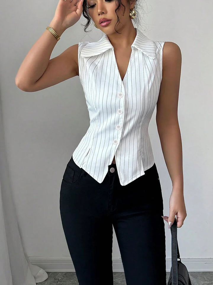 Woman wearing white pinstripe sleeveless collared top with black pants, holding black handbag