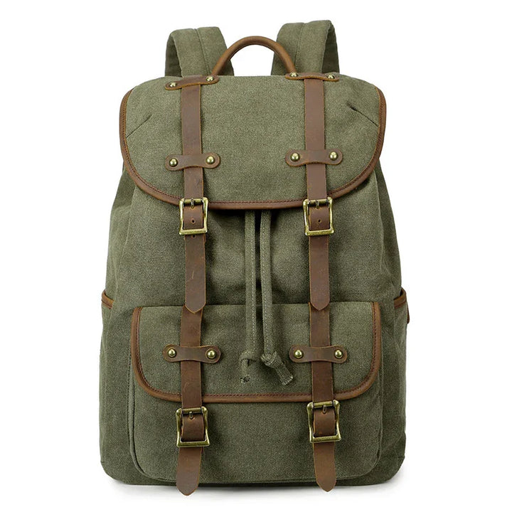 Green canvas backpack with brown leather straps, brass buckles, front pocket, and drawstring closure