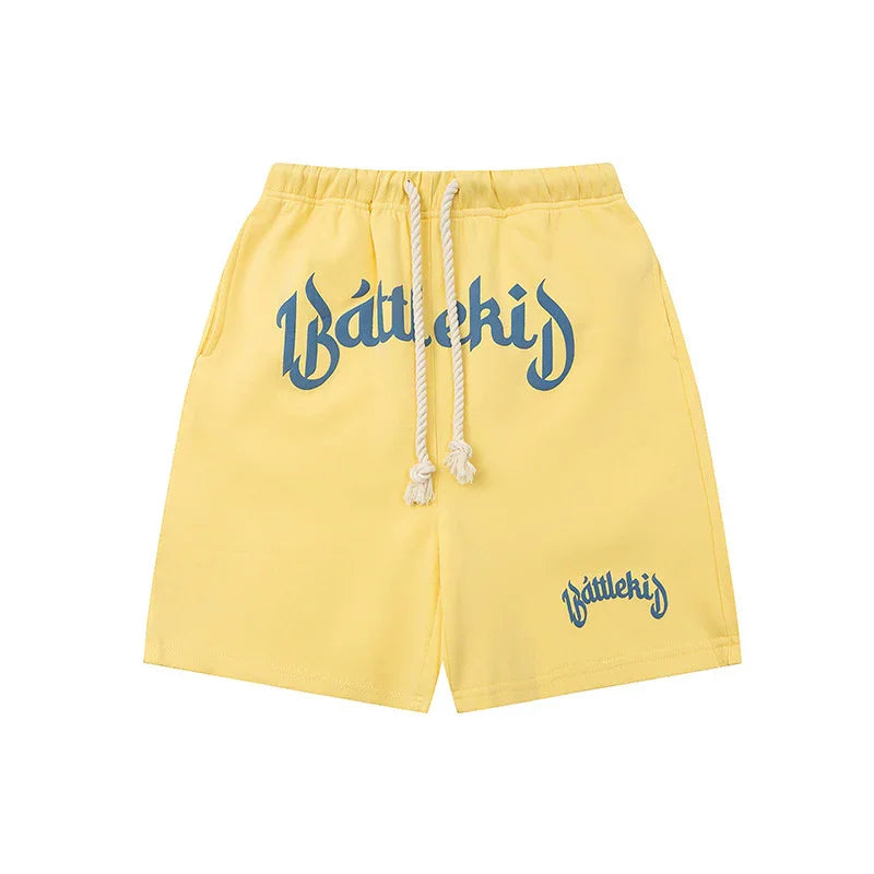 Yellow drawstring shorts with blue 'Battlekid' lettering on front and left leg